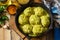 Meatballs with bulgur in sour cream and turmeric sauce in a cast-iron skillet on a rustic countertop.