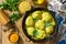 Meatballs with bulgur in sour cream and turmeric sauce in a cast-iron skillet on a rustic countertop.