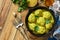 Meatballs with bulgur in sour cream and turmeric sauce in a cast-iron skillet on a rustic countertop. Top view flat lay.