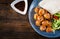 Meatballs in sweet and sour glaze on a plate with pita bread and vegetables