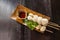 Meatballs toasted on wood dish and a cup of sauce decorated with coriander placed on the table dark wood.