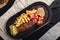 Meatloaf with french fries and vegetables on a wooden board, traditional English food. Food photo, copy space.