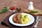 A meatloaf with mushrooms and red sweet pepper on a white plate with a garnish of mashed potatoes