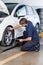 Mechanic Adjusting Car Tire With Rim Wrench At Garage