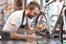 Mechanic in a bicycle repair shop oiling the chain of a bike