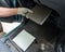 A mechanic changes the cabin air filter of a car.