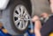 Mechanic changing car wheel in auto repair shop. serviceman wren