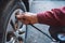 Mechanic checks tire pressure using pneumatic compressor with pressure gauge