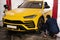 Mechanic checks tire pressure in yellow sport car suv