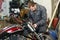 The mechanic connects the electrical cables of the motorcycle.