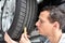 Mechanic controls tread depth of a car tyre