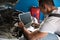 Mechanic with diagnostic tool in car workshop