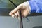 The mechanic in disposable gloves holds the damaged wiper blade.