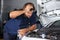 Mechanic Examining Car Engine At Repair Shop