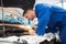 Mechanic examining under hood of car with torch