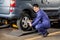 Mechanic Fixing Car Tire Pneumatic Wrench At Garage