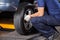 Mechanic Fixing Car Tire At Repair Shop