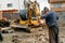 Mechanic fixing excavator on construction site