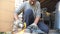 Mechanic grinding metal using circular saw. Worker cutting detail in garage or workshop. Man sawing iron part. Repairman