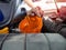 Mechanic hand pouring fresh  engine oil through orange funnel into the car engine