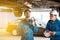 Mechanic and his assistant examining the car bottom with flash light. Auto car repair service center. Professional service