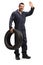 Mechanic holding a vehicle tire and waving