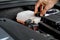 mechanic inspects the expansion tank with pink antifreeze. Vehicle coolant level in the car\\\'s radiator system. auto parts