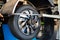 Mechanic man balancing a car wheel on automated machine