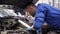 Mechanic man with lamp repairing car at workshop 5