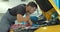 Mechanic man with lamp working at workshop. Car repair service. Professional mechanic is working on a car in a car