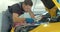 Mechanic man with lamp working at workshop. Car repair service. Professional mechanic is working on a car in a car