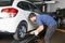 Mechanic measuring tire pressure as a service