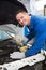 Mechanic pouring oil into car