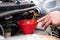 mechanic pouring oil to vehicle engine. serviceman changing motor oil in automobile repair service. maintenance & checkup in car