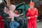 The mechanic in red uniform opens the car door when the customer comes to repair the car