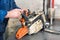 Mechanic repairing a chainsaw. Man repairing a chainsaw in workbench.