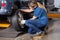 Mechanic Replacing Car Wheel At Repair Shop