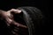 Mechanic\\\'s hands expertly cradling a new car tire, emphasizing its durability and tread design