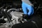 Mechanic`s hands are opening the oil filler cap in the car engine