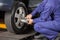 Mechanic Screwing Car Tire With Pneumatic Wrench