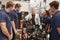 Mechanic showing parts of an engine to apprentices, close up