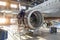 Mechanic specialist repairs the maintenance of engine of a passenger aircraft in a hangar