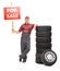 Mechanic standing by a pile of tires and holding for sale sign