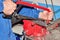 Mechanic starting to cut an iron plate by hand with a metal saw, selective focus on the saw blade