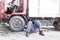 Mechanic under truck reparing dirty greasy oily engine with prob