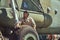 Mechanic in uniform and flying helmet wash large military helicopter.