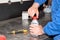 Mechanic unscrewing the cap of a plastic bottle containing brake fluid