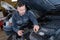 Mechanic unscrewing oil tank in auto repair
