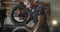 Mechanic unscrews and rotates an alloy wheel on tyre changer machine on service