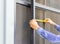 Mechanic uses tape measure to measure door